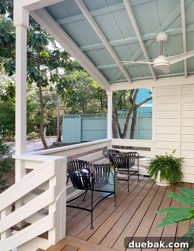 Blue Ceiling On Covered Porch With Ceiling Fan And Black Chairs