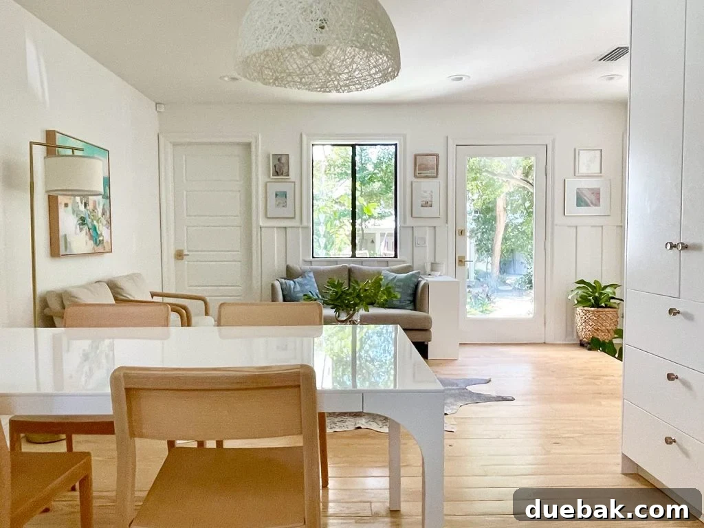 View Towards Sitting Area With White Modern Dining Table And Wood Chairs